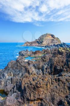 Travel on the volcanic island of Madeira. Concept of exotic and ecological tourism. Picturesque rocks and stones  at coast of Atlantic