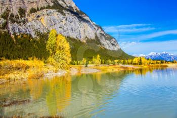 Rocky Mountains are reflected in the smooth water of Lake Abraham. Indian Summer in the Rockies of Canada. Concept of ecological and active tourism
