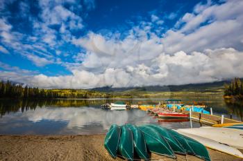 Wooden boat dock with moored pleasure boats and benches. Fluffy cumulus clouds over the Pyramid mountain and Pyramid Lake