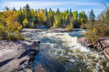 Old Pinawa Dam Provincial Heritage Park. Warm autumn day. Foam water rapids on the smooth stones of the Winnipeg River. The concept of ecological and adventure tourism