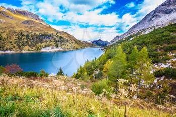 The concept of ecological and extreme tourism. The magic and harmony of the Dolomites. Glacial lake with clear cold water. Mountain Lake Lago di Fedaia, Dolomites