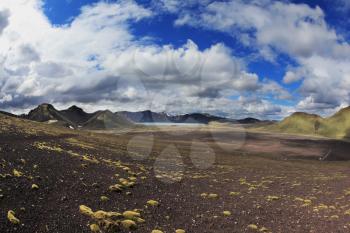 National Park Landmannalaugar in July. Green and pink mountain slopes and snowy white residues from last winter