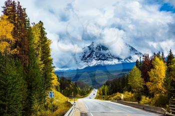 The astonishing Highway 93 Icefields Parkway passes among the snow-capped mountains. The grandiose nature of the Rockies of Canada. The concept of active car tourism