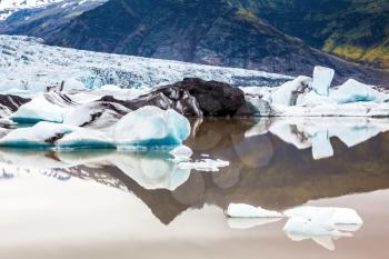 The largest glacier in Iceland - Vatnajokull  in the summer. Huge ice floes have broken away from a glacier and drift towards the ocean. The concept of northern extreme tourism