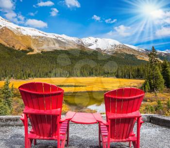 Two red comfortable chaise longue in a swampy valley. The beautiful nature in northern Rocky Mountains of Canada