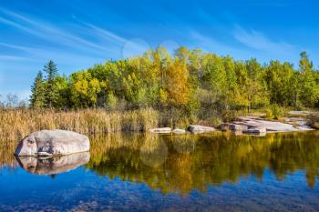 The smooth stones in the Winnipeg River. Old Pinawa Dam Provincial Heritage Park. The concept of travel Around the World. Warm autumn day