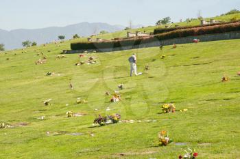 Man visiting grave in cemetery