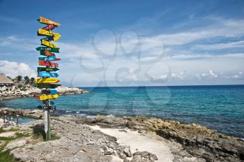 Pole indicating the direction and distance to several countries, from the Mayan Riviera