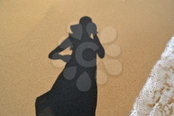 Woman shadow on the beach sand