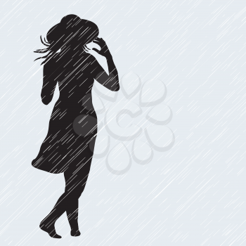 Woman with hat walking in the rain in a windy day