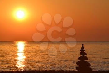 Relax zen stones balanced at sunrise at seashore
