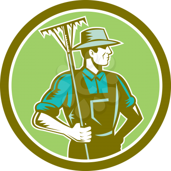 Illustration of organic farmer holding rake on shoulder facing side set inside circle on isolated background done in retro woodcut style.