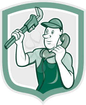 Illustration of a plumber holding monkey wrench and telephone talking set inside shield crest done in cartoon style on isolated background.