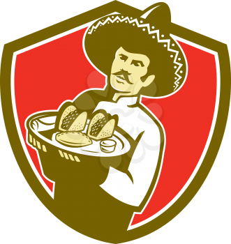 Illustration of a Mexican chef cook wearing hat sombrero serving plate with tacos on isolated background set inside shield crest done in retro style. 