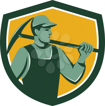 Illustration of a coal miner wearing hat holding crossed pick axe on shoulder looking to the side set inside shield on isolated background done in retro style.