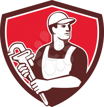 Illustration of a plumber wielding monkey wrench looking to the side viewed from front set inside shield crest on isolated background done in retro style. 