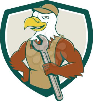 Illustration of a american bald eagle mechanic holding spanner looking to the side with one hand on hips set inside shield crest done in cartoon style. 
