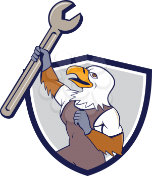 Illustration of a mechanic american bald eagle holding spanner looking to the side set inside shield crest on isolated background done in cartoon style. 