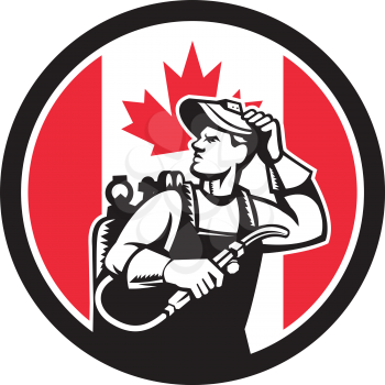 Icon retro style illustration of a Canadian welder or lit operator with visor holding welding torch with Canada maple leaf flag set inside circle on isolated background.
