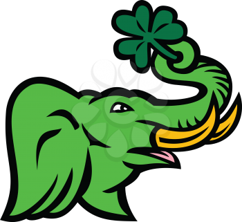 Icon retro style illustration of green elephant with big tusk holding a giant Irish shamrock using it's trunk viewed from side on isolated background.