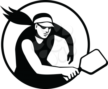 Retro style illustration of a female pickleball player, a paddleball sport that combines elements of tennis, badminton, and table tennis set inside circle isolated background done in black and white.