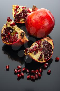 Royalty Free Photo of a Pomegranate and an Open One on Black