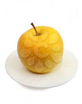 Yellow apple on a white plate on a white background, isolated