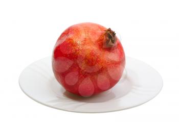 Pomegranate on a white platte on white background, isolated.