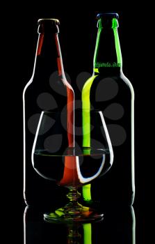 Bottles of lager beer from green and brown glass, isolated on a black background.