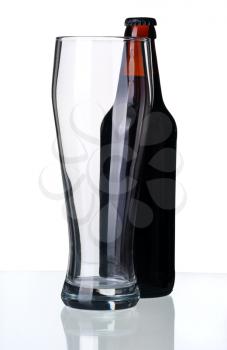 Bottle of dark beer and glass, isolated on a white background.