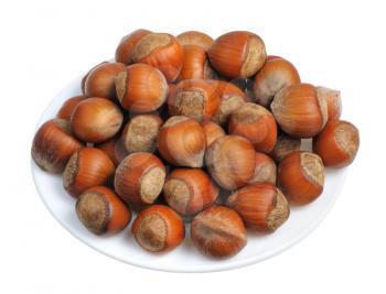 Hazelnuts on a white plate on a white background, isolated