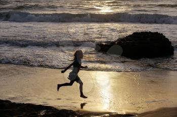 Girl runs along the shore of the Mediterranean Sea in Israel