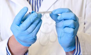 Scientist holds syringe for laboratory analysis