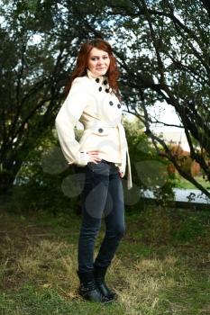 Portrait of a redheaded girl near a tree (autumn colors).