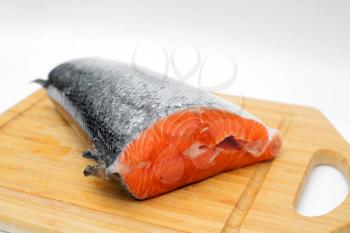 A piece of salmon in the fish section on a cutting board