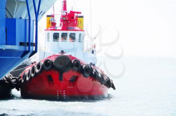 Red Tug Boat in the sea near big vessel