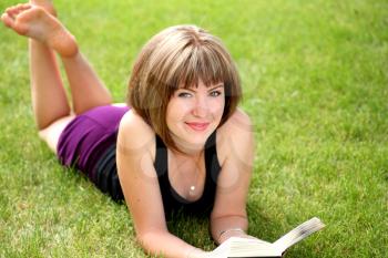 Portrait of beautiful relaxed young female student with a book