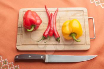 Red peppers on wood with knife (chilli sliced)