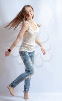 Young female dancing, fluttering on the wind hair, over white background