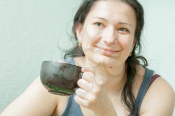 Close-up of a beautiful girl with a cup near the face indoors