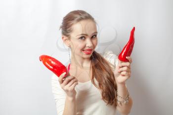 beautiful young blond woman with red peppers against white background