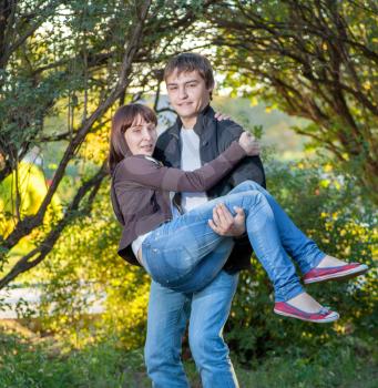 Happy young couple. Holding women on the hands and fav fun a lot of positive emotions