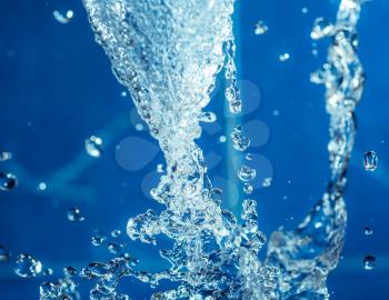 stream of the water in the air, water drops levitating on blue