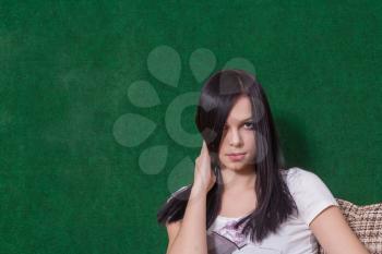 serious brunette on green head and shoulders shot