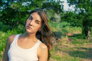 Pretty women looking at camera. Girls head and shoulders outdoor shot in white tank-top