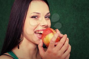 women with apple near face, smiling, closeup view