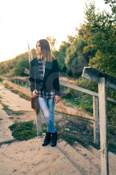 Waiting in loneliness. Blonde girl alone outdoors  in jeans toned image
