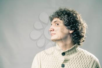 Profile view of a curly white man in studio