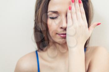 Closed eyes women hiding her eye by hand head and shoulders image