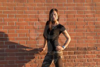 Brunette elegant woman in front of brick wall backround.